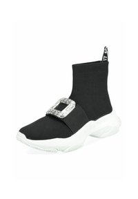 Baskets style chaussette noires en matériau élastique, présentant un grand accent de boucle argentée et une semelle épaisse blanche. Tissu texturé et forme épurée.