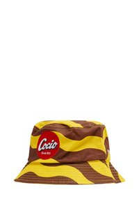 Bucket hat i brun och gul vågmönster, med en röd cirkulär patch som har ordet "Cocio" och "Sedan 1951" tryckt på.
