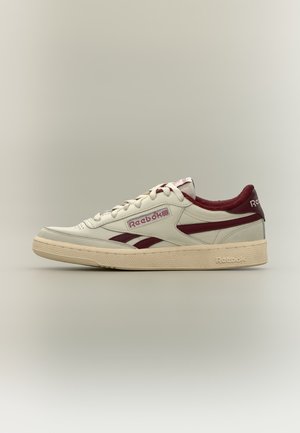 Λευκό και μπορντό χαμηλό παπούτσι Reebok με κορδόνια, λογότυπο στο πλάι και στη φτέρνα και υφασμένο μπεζ σόλα σε απλό φόντο.