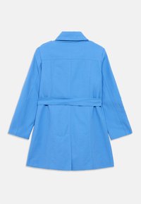 Μπλε βαμβακερό παλτό με γιακά, μακριά μανίκια, εφαρμοστή μέση και σχέδιο με ζώνη. Διαθέτει διακριτικές ραφές και ίσιο τελείωμα.