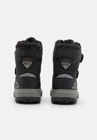 Schwarze wasserdichte Stiefel mit Kunstfellkragen und Klettverschlüssen, ausgestattet mit einer strukturierten Außenseite und geriffelten Gummisohlen für besseren Halt.
