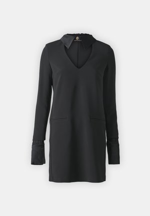 Melna kleita ar V-veida dekoltē, garām piedurknēm ar savilktām aprocēm, divām priekšējām kabatām un gludu auduma apdari, kurai ir apkakles detaļa.