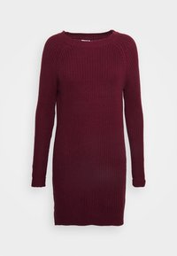 Vestito in maglia bordeaux con maniche lunghe, texture a coste, scollatura rotonda e polsini aderenti. La lunghezza arriva a metà coscia.