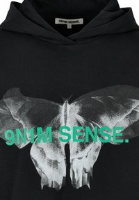 Felpa nera con cappuccio che presenta una grande grafica dettagliata di una farfalla grigia, con il testo verde brillante "9N1M SENSE." sopra il design. Tessuto morbido.