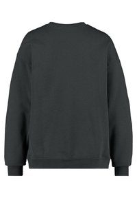 En enkel svart långärmad crewneck sweatshirt sedd bakifrån med ribbade ärmslut och nederkant.