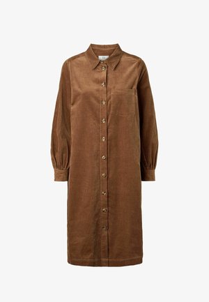 Ruskea corduroy-mekko, jossa on terävä kaulus, pitkät liehukevyiset hihat, edessä napitus ja rintatasku. Pystysuora ribbineulos.