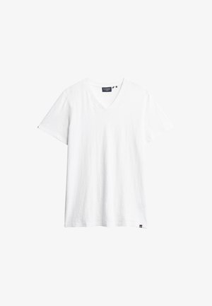 Biała koszulka z dekoltem w serek wykonana z miękkiego materiału. Krótkie rękawy o luźnym kroju. Mała metka marki na dolnym lewym brzegu. Minimalistyczny design.