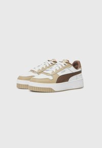 Puma sneakers featuring a beige and white synthetic upper, a brown leather accent, white laces, and a thick white sole with textured detail.