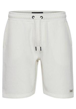 White cotton sweat shorts with an elastic waistband, black drawstring, side pockets, and a small brand label on the left leg.