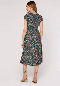 Vestido midi floral con fondo verde, manga corta acampanada, cintura fruncida y flores multicolores. Combínalo con tacones nude de tiras.