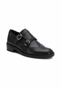 Zapato negro de piel con dos hebillas, detalle perforado, punta redonda y un tacón bajo apilado. Las hebillas son de metal plateado.