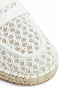 Witte espadrille met een geweven mesh bovenwerk, met een platte, ronde neus en een natuurlijke jute rand langs de zool.