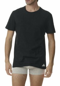 Czarny krótki rękaw T-shirt wykonany z bawełny. Okrągły dekolt, luźny krój, z białym logo Adidas na dolnym lewym zijść.