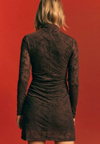 Br�ązowa sukienka z haftem kwiatowym, z długimi rękawami, dopasowanym górą i marszczeniami, przechodząca w rozkloszowany dół. Widoczna subtelna faktura.