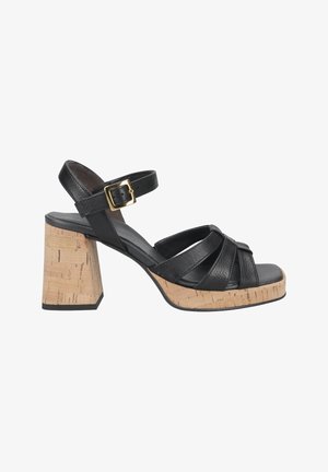 Zwarte leren sandalen met hakken en een kurken blokhak, voorzien van een kruisbandontwerp en een enkelband met een gouden gesp.