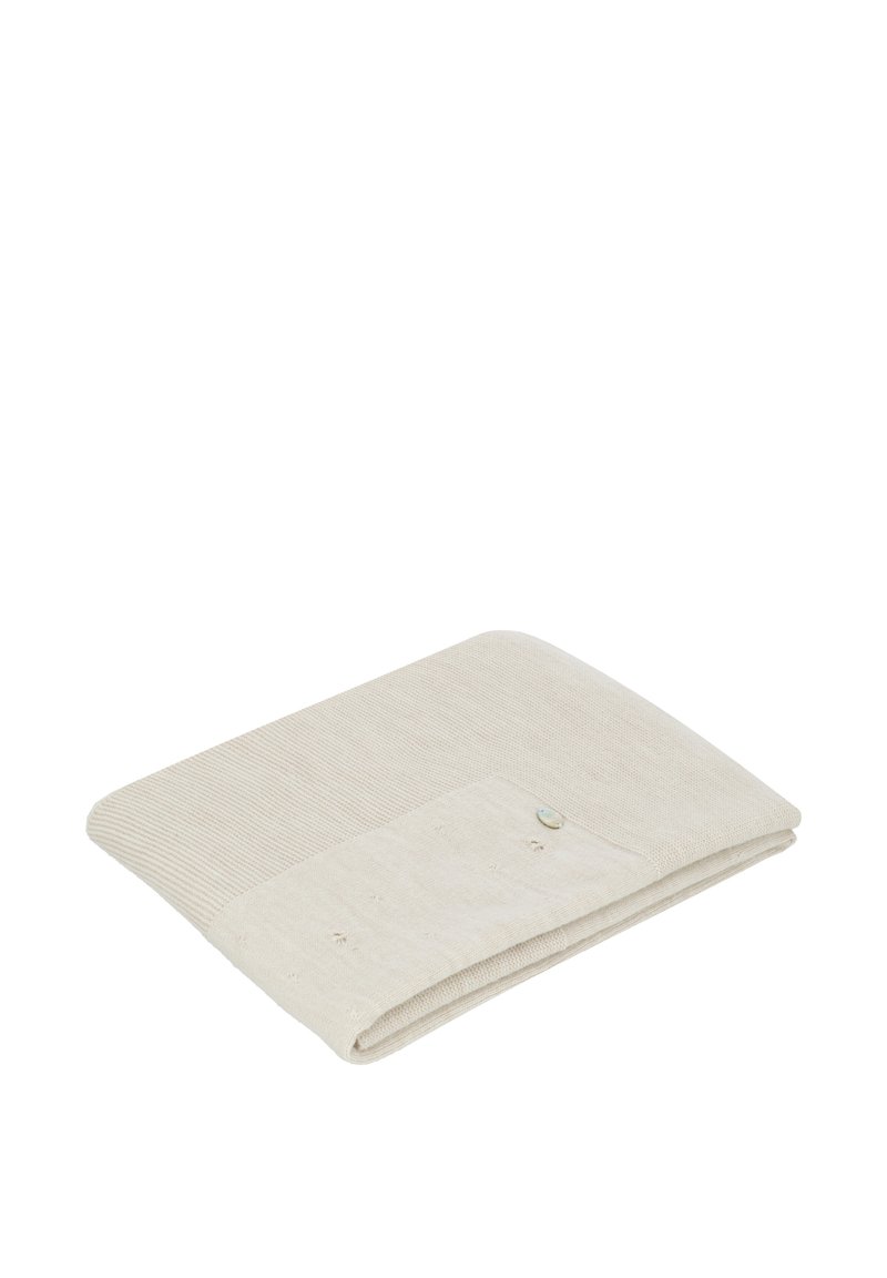 Tela arrugada de color beige claro con una sección texturizada de canalé y un área lisa, que cuenta con un pequeño botón decorativo en un lado.