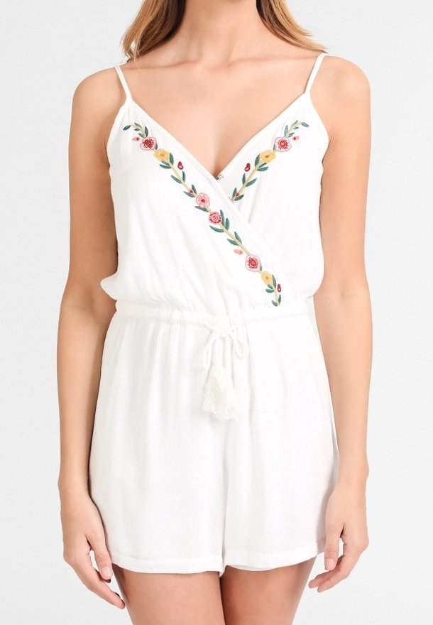 Mono sin mangas blanco con bordado floral a lo largo del escote en V, tirantes finos y cintura con cordón ajustable y borlas.