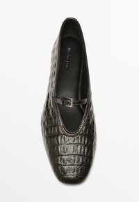 Dunkelbraune Lederflatschuhe mit Krokodilprägung, quadratischer Zehenpartie und einem dünnen Schnallenriemen über dem Spann, von oben betrachtet.