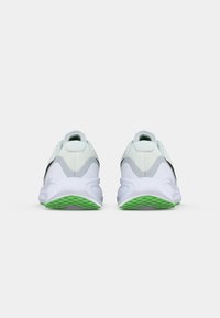 Λευκά αθλητικά παπούτσια με υφασμάτινη επένδυση και γκρι λεπτομέρειες. Διαθέτουν μαλακό πάτο με πράσινη σόλα και στρογγυλή σχεδίαση τακουνιού.