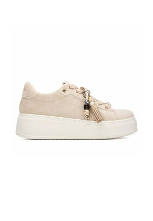 Zapatilla plataforma de ante beige con suela blanca gruesa, cordones delanteros y borla decorativa con cuentas en el lateral.