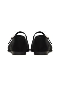 Zapatos de ante negro con un acabado suave, diseño sin parte trasera y correa delgada en el tacón. Presentan un pequeño lazo decorativo.
