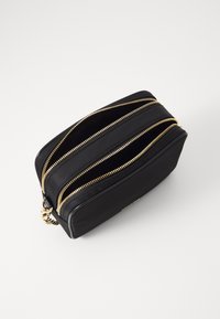 Melna kabatas soma ar elegantu dizainu, apgādāta ar zelta tonī iešuvēm un akcentiem. Virsma ir gluda, un forma ir taisnstūra.