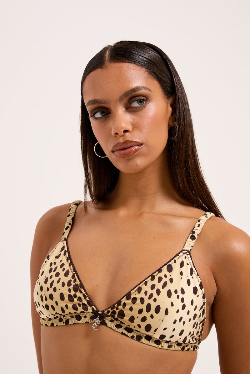 Trīsstūra formas bikini augšdaļa krēmkrāsā ar brūnu leopardu plankumu rakstu. Funkcijas ruffled malās, regulējamas siksnas un centrālais dekoratīvais bloķējošs elements.