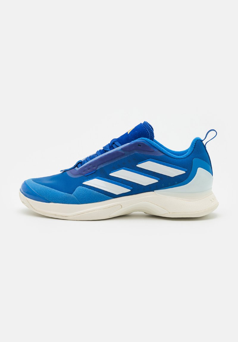 Scarpa atletica blu con una tomaia sintetica liscia, caratterizzata da strisce bianche, suola ammortizzata e parte posteriore testurizzata per supporto.