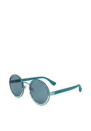 Occhiali da sole rotondi color turchese con lenti scure e montatura sottile, inclinati per mostrare un lato e la vista frontale su sfondo bianco.