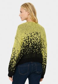 Gebreide trui met een gradientontwerp, met helder geel dat overgaat in zwart, oversized pasvorm, geribbelde zoom en dikke textuur.