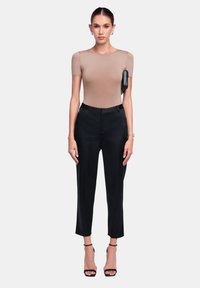 Body aderente beige con maniche corte abbinato a pantaloni tailored neri; include una borsa nera elegante e tacchi alti neri open-toe.