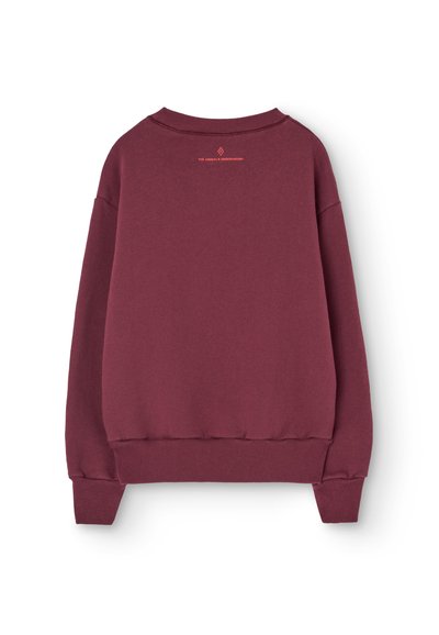 Bordo bluza z okrągłym dekoltem, ściągaczami przy rękawach i dolnym zakończeniu. Posiada małe pomarańczowe logo na tylnej części dekoltu. Miękka tekstura.