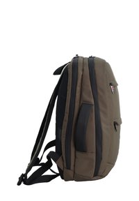 Mochila verde oscura de forma rectangular, con laterales acolchados, múltiples compartimentos con cremallera y correas negras. Superficie texturizada con detalles.