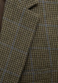 Tessuto a quadri marrone e verde con accenti blu; motivo tessuto con piccoli controlli; composto da materiale tessuto per un aspetto sartoriale.