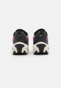 Black sneakers with purple and pink accents, textured material, and a chunky white sole. Features a pull tab and visible air cushioning.