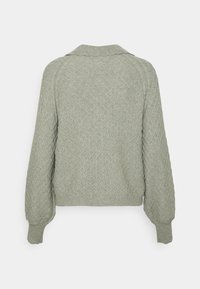 Grøn, tekstureret sweater med et diamantmønster, ribbede manchetter og krave. Designet har en afslappet pasform og lange ærmer.