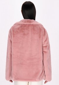 Giacca in pelliccia sintetica rosa con colletto, vestibilità over, maniche lunghe e una texture morbida, mostrata da dietro su uno sfondo uniforme.