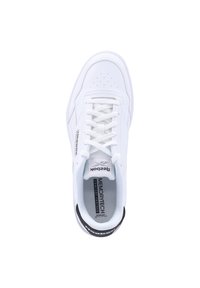 Zapatilla deportiva blanca con parte superior de cuero liso, puntera perforada y cordones blancos. Presenta el logo "Reebok" en el lateral y un detalle negro en el talón.