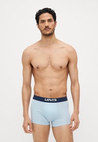 Ljusblå boxerkalsonger med midjeband i marinblått som har vit "Levi's" logotyp. Mjuk tyg med en tight passform.