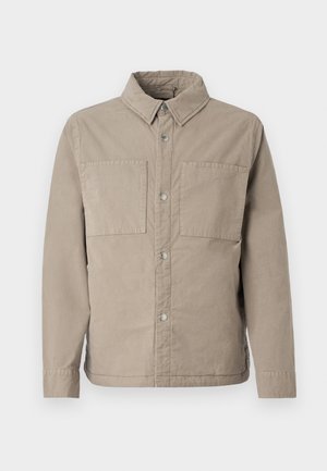 Beige button-up shirt made of textured cotton, featuring two chest pockets, a pointed collar, and long sleeves with buttoned cuffs.