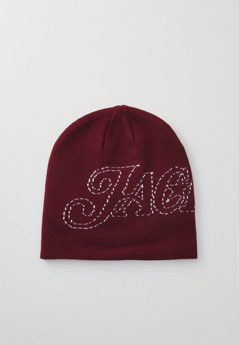 Maroon knitted beanie with white embroidered logo, featuring a curved script design and a rounded shape at the top. Soft texture.