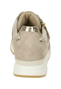 Beige Wildlederschuh mit einer weißen Gummisohle, einer metallischen Akzentuierung an der Ferse und einem gepolsterten Kragen für zusätzlichen Komfort.