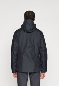 Donkerblauwe waterdichte jas met capuchon, met een gestroomlijnd ontwerp, textuurstof en versterkte naden voor duurzaamheid.