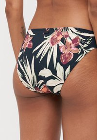 Blomstrete bikinibunn med svart bakgrunn som har rosa orkideer og grønne blader, glatt stoff, midjehøyde og sydd midjebånd.