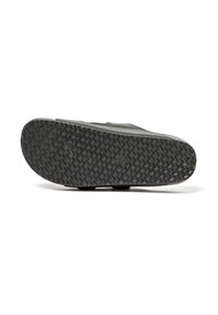 Suela de zapato con un patrón de goma negra texturizada y ranuras para tracción, diseño plano y forma minimalista sin marcas visibles.