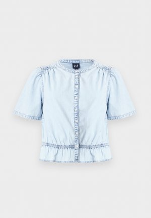 Ανοιχτό μπλε τζιν μπλούζα με κοντά μανίκια, κουμπιά μπροστά, σιδερωμένη μέση, μικρό βολάν γιακά και διακριτικές πιέτες στον ώμο.