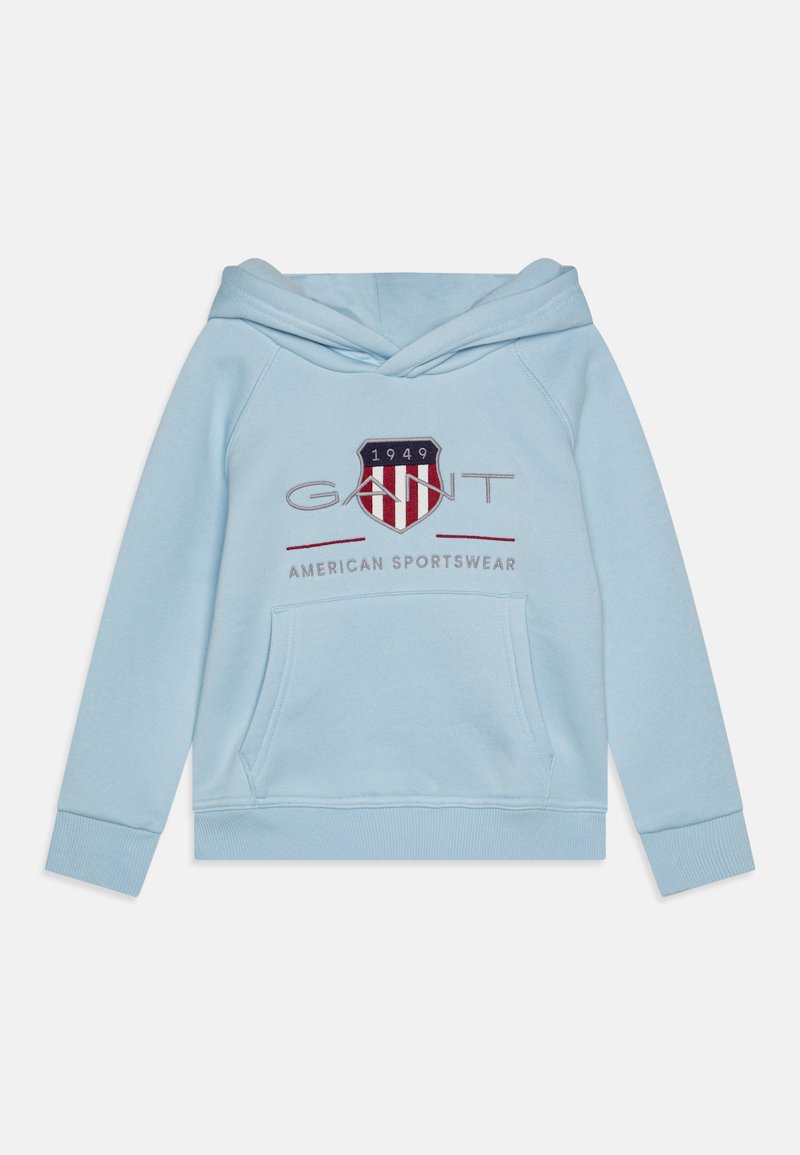 Sudadera azul clara hecha de tela suave, con un bolsillo frontal, una capucha triangular y un logo bordado con un escudo rojo y marino.