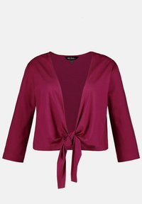 Burgundský zkrácený kardigan s dlouhými rukávy, zavazováním vpředu a měkkou jersey tkaninou. Obsahuje široký výstřih a jednoduchý design.