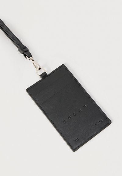 Μαύρος δερμάτινος κάτοχος καρτών με δύο υποδοχές για κάρτες, με ανάγλυφο το λογότυπο "HOOGAN", προσαρτημένος σε μαύρο λουράκι με ασημένιο κόμπρα.