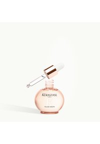 Kérastase Glaze Drops en un frasco redondo transparente de color rosa con tapa de oro rosa y gotero blanco, con texto de marca en negro.